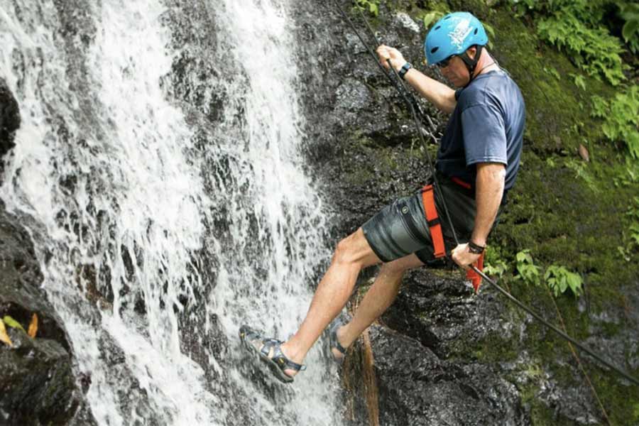 A guest of the Rios Lodge enjoying waterfall climbing on the Pacuare River