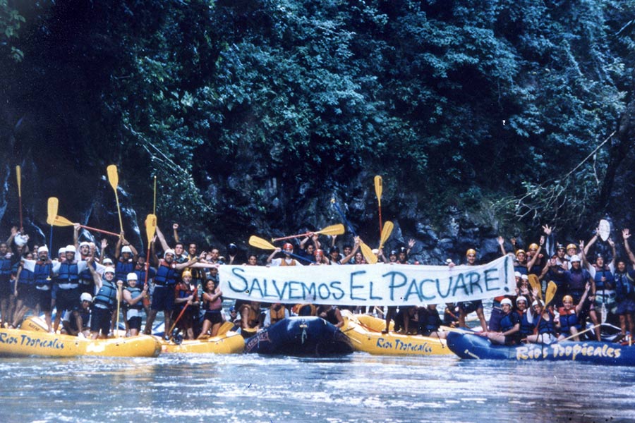 Rafters holding a sign that says "Salvemos El Pacuare!" on the Pacure River in Costa Rica